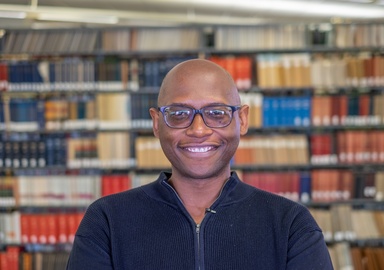 Man smiling against library background